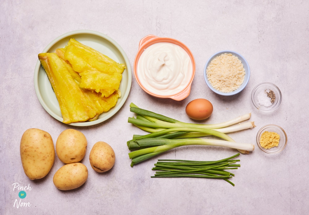 The raw ingredients for Pinch of Nom's slimming-friendly Smoked Haddock and Spring Onion Fishcakes are laid out on a kitchen counter, ready to begin cooking.