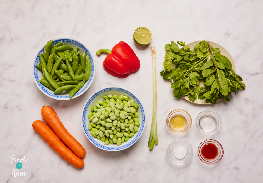 The ingredients for Pinch of Nom's Edamame and Carrot Salad are laid out on a kitchen counter, ready to begin cooking.