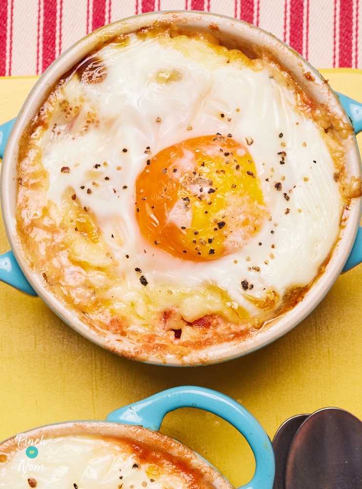 An ovenproof, bright blue ramekin dish is filled with Pinch of Nom's slimming-friendly Sausage, Mushroom and Tomato Breakfast Bake, topped with a runny fried egg.