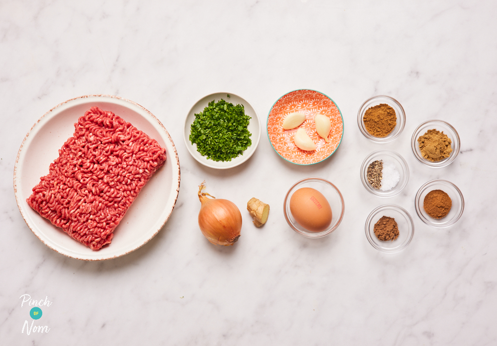 The ingredients for Pinch of Nom's Beef Kofta Kebabs are laid out on a kitchen countertop. Each ingredient is weighed out in a separate container, ready to begin cooking.