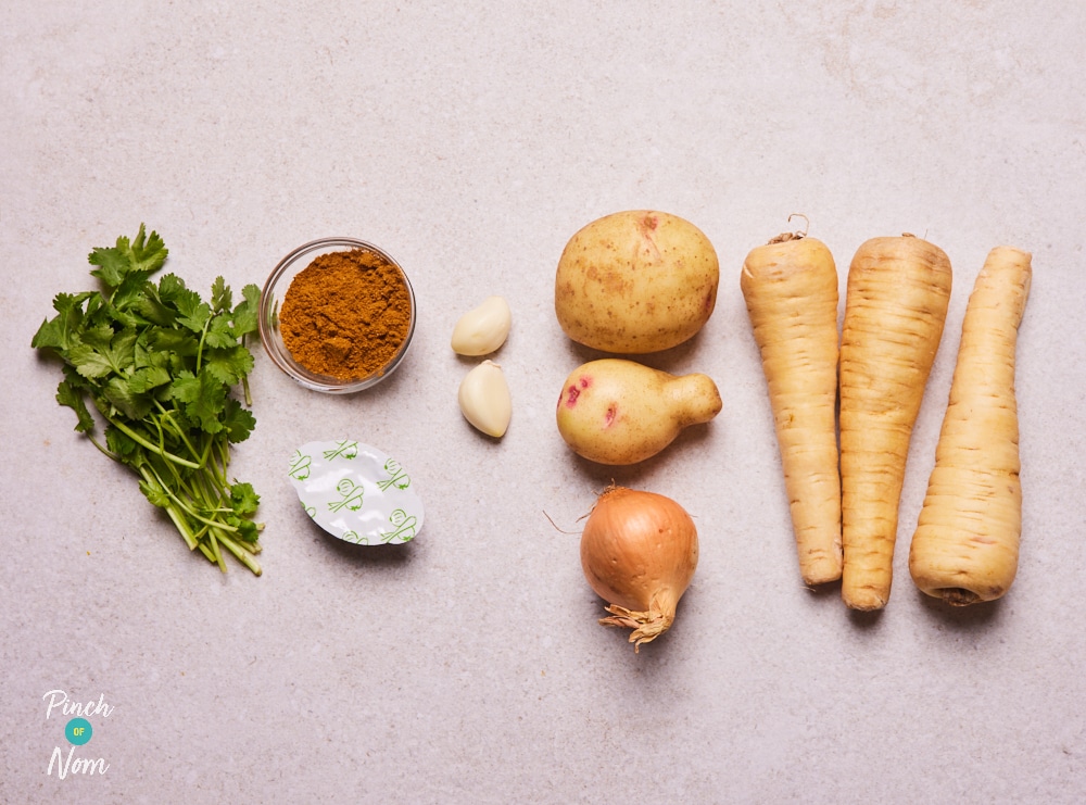 The ingredients for Pinch of Nom's Curried Parsnip Soup are laid out on a kitchen surface, ready to begin cooking.