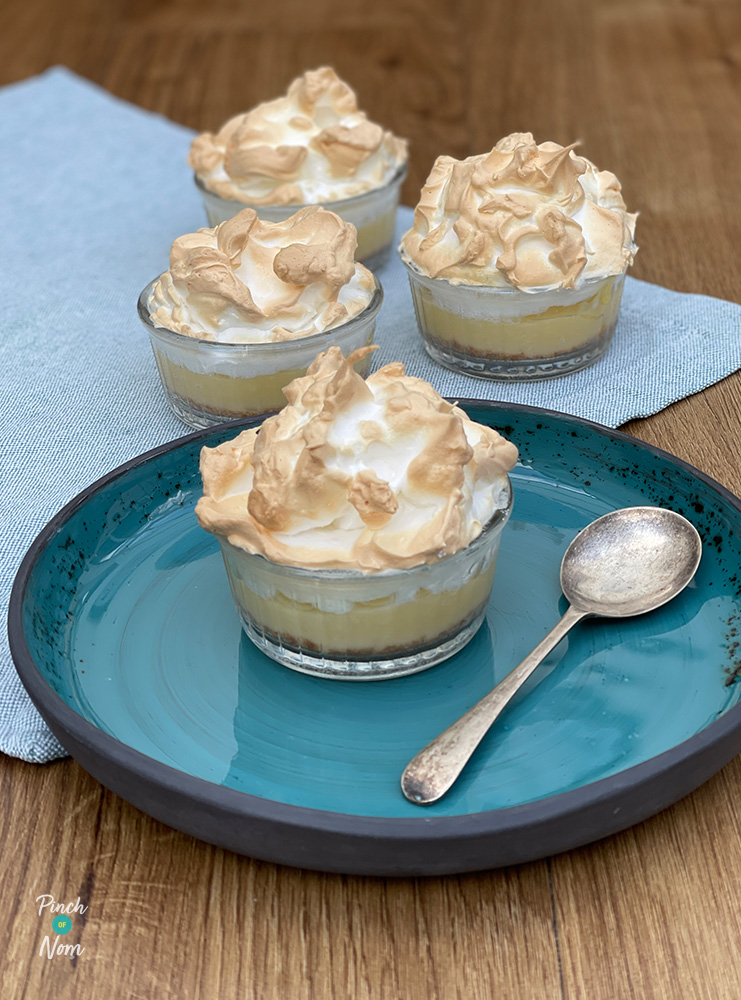 Pinch of Nom's Lemon Meringue Pots from the Pinch of Nom: Budget cookbook are served in four individual ramekins, with a spoon waiting to tuck into the zingy, lemon meringue inspired centres.