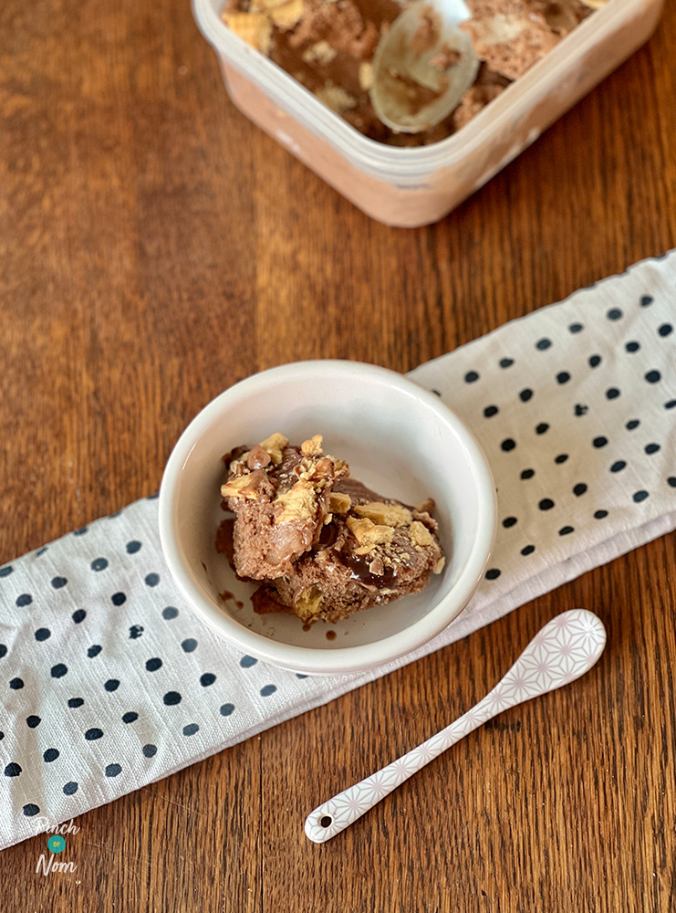 A scoop of Pinch of Nom's Malt Chocolate Ice Cream from the Pinch of Nom: Budget cookbook is served in a small white bowl with a spoon waiting to dig in.