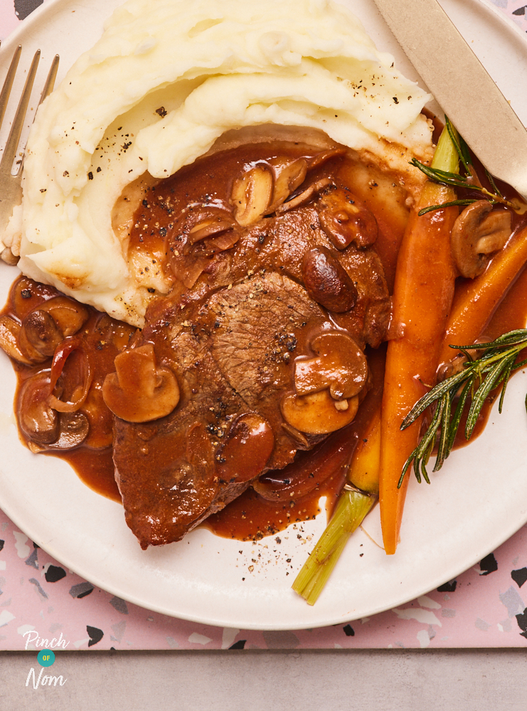 Plate with plenty of redcurrant gravy, lamb steaks, carrots and mashed potatoes plated up.
