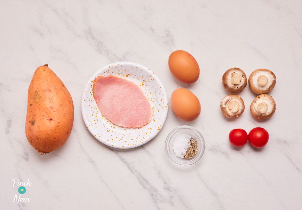 The ingredients for Pinch of Nom's Sweet Potato Breakfast Toast are laid out on a tabletop. There is sweet potato, a bacon medallion, eggs, mushrooms, tomatoes, salt and pepper.
