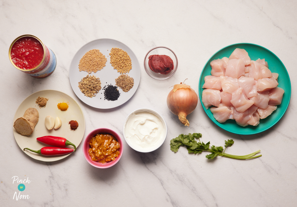 The ingredients for Pinch of Nom's Chicken and Mango Pickle Curry are laid out on a kitchen counter, ready to start cooking.