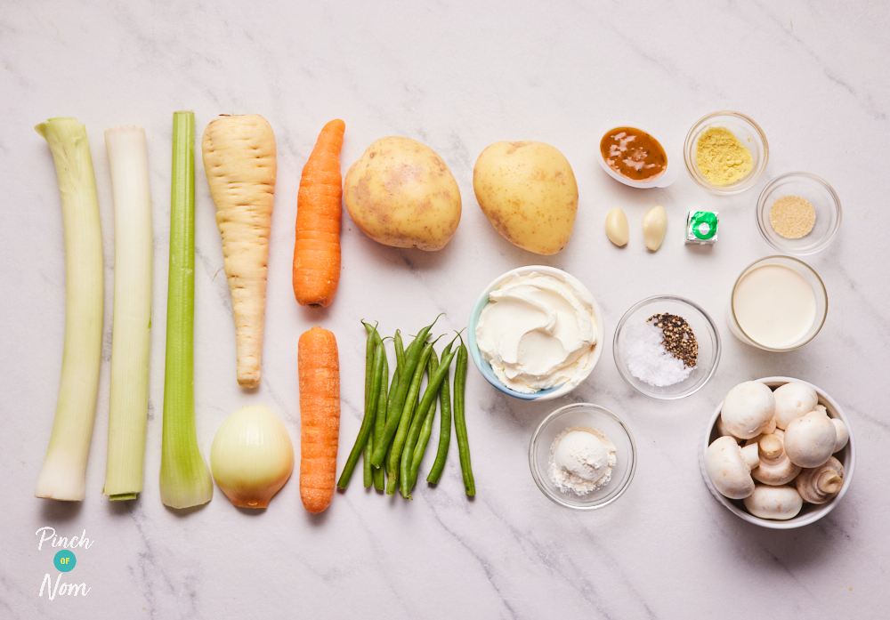 The ingredients for Pinch of Nom's Creamy Vegetable Hotpot are set out on a kitchen counter, ready to get cooking.
