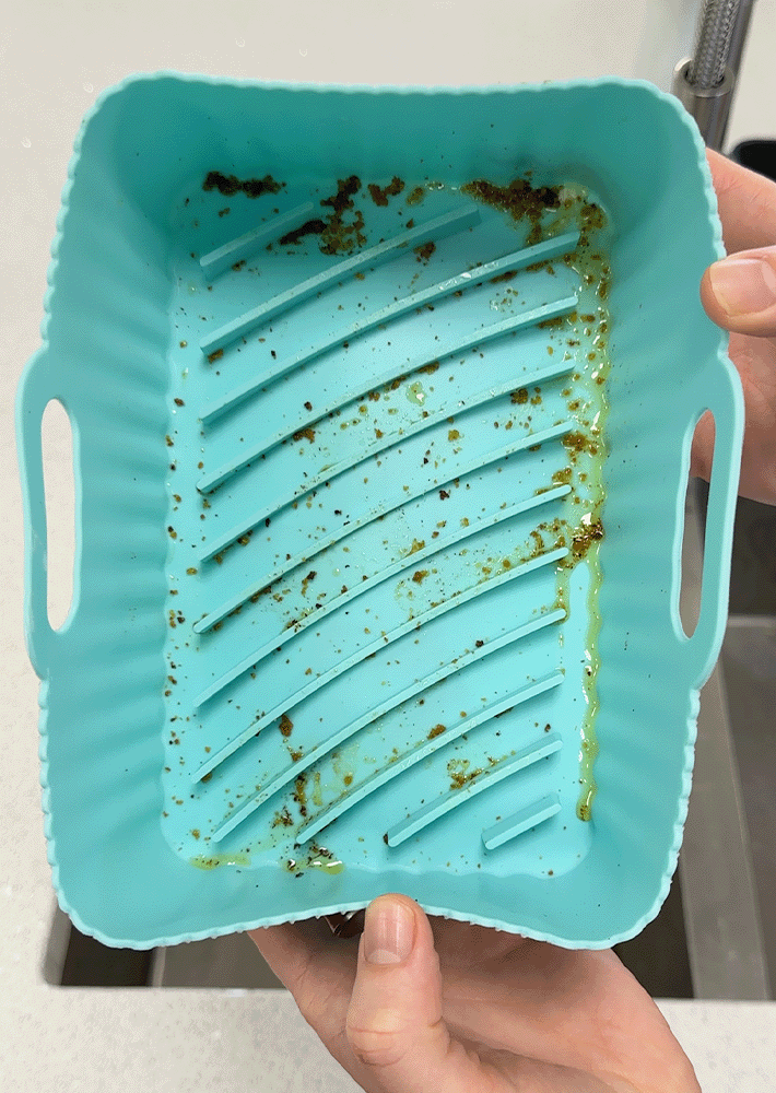 A silicone liner from an air fryer drawer, dirty with grease and grime from air-frying.