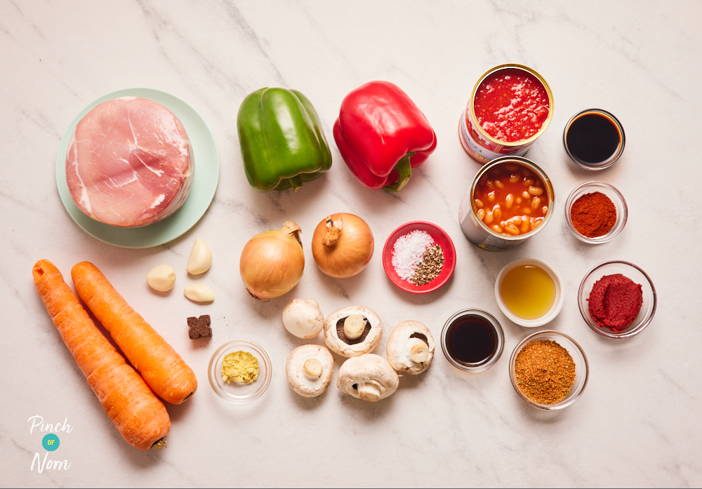 The ingredients for Pinch of Nom's BBQ Gammon Stew are laid out on a white marbled countertop, ready to start cooking.
