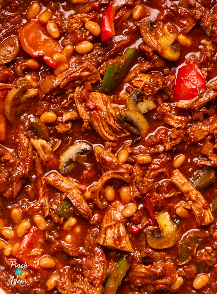 A close-up photo of Pinch of Nom's BBQ Gammon Stew. The stew is packed with colourful vegetables, baked beans and shredded gammon, in a deep red tomatoey sauce.