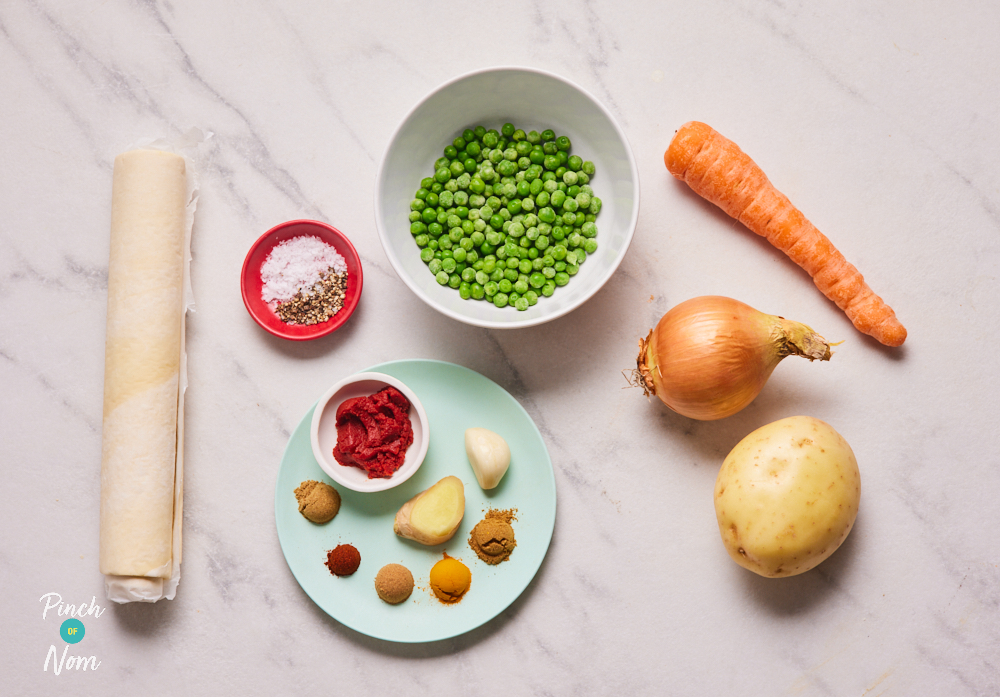 The ingredients for Pinch of Nom's Samosa Swirls are laid out on a white marbled countertop, ready to start cooking.