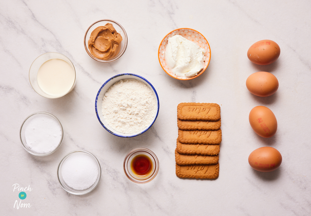 The ingredients for Pinch of Nom's Biscoff Swiss Roll are laid out on a white marbled countertop, ready to start cooking.