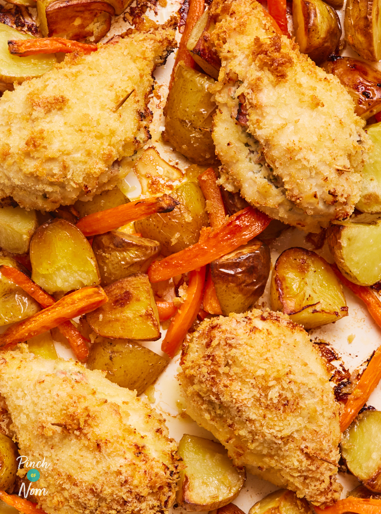 A close up of the Chicken Kyiv Traybake fresh from the oven. The chicken is crispy on the outside, the potatoes are golden brown and the carrots are cooked through.