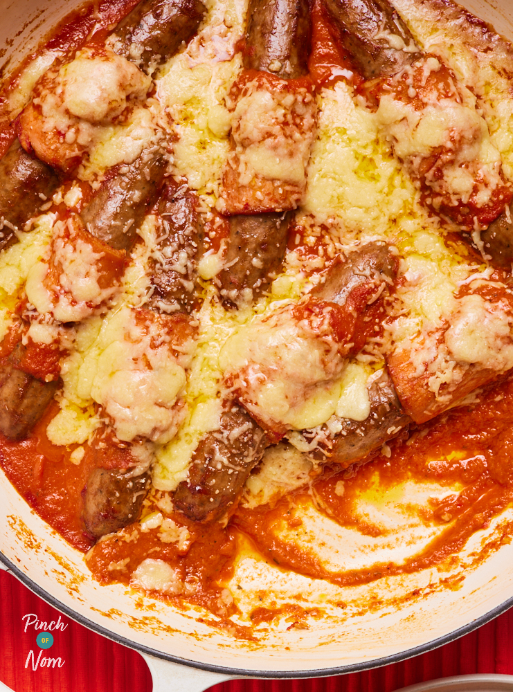 A close-up of Pinch of Nom's Hunter's Sausages recipe in a casserole dish filled with homemade sauce and topped with melted reduced-fat cheese.