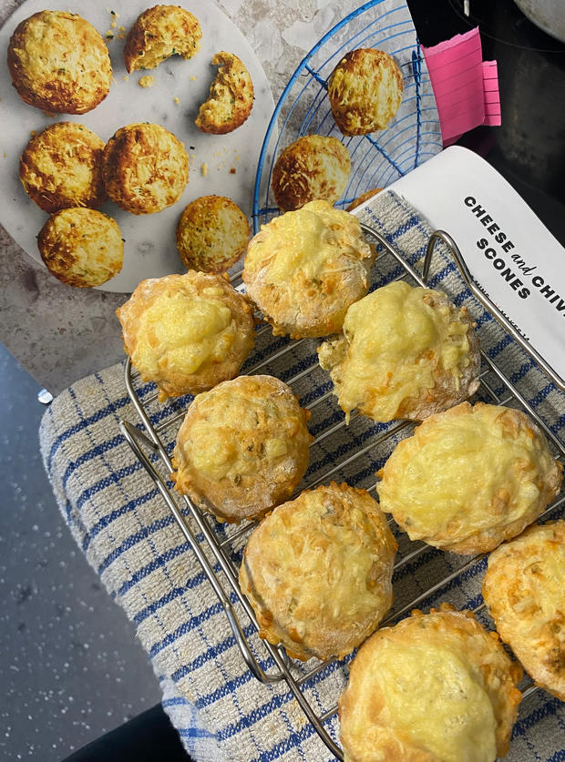 A baking tray is laid with a batch of freshly air-fried Cheese and Chive Scones from page 164 of Pinch of Nom's Air Fryer cookbook.