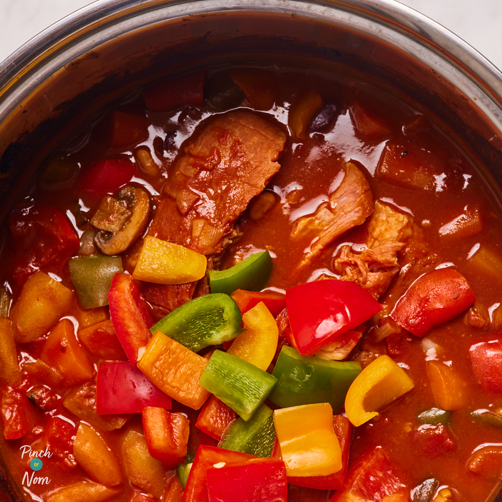 A close-up shows red, green and yellow diced peppers, ready to be mixed into the almost-cooked Campfire Stew.