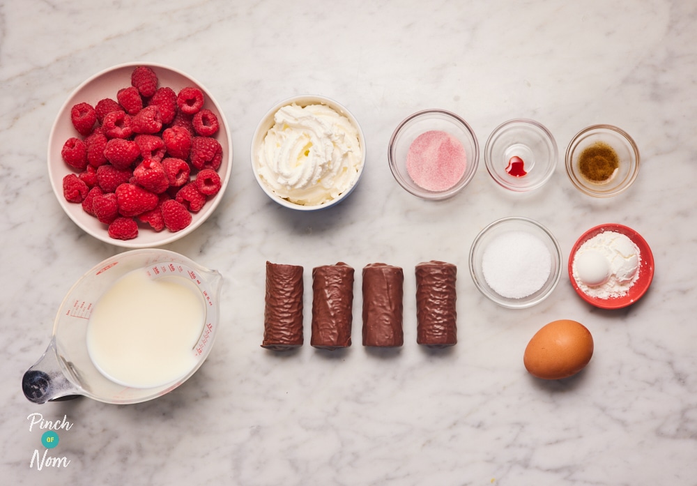 The ingredients for Pinch of Nom's slimming-friendly Pink Raspberry Trifle are laid out on a kitchen surface. Each ingredient is measured out, ready to begin cooking.