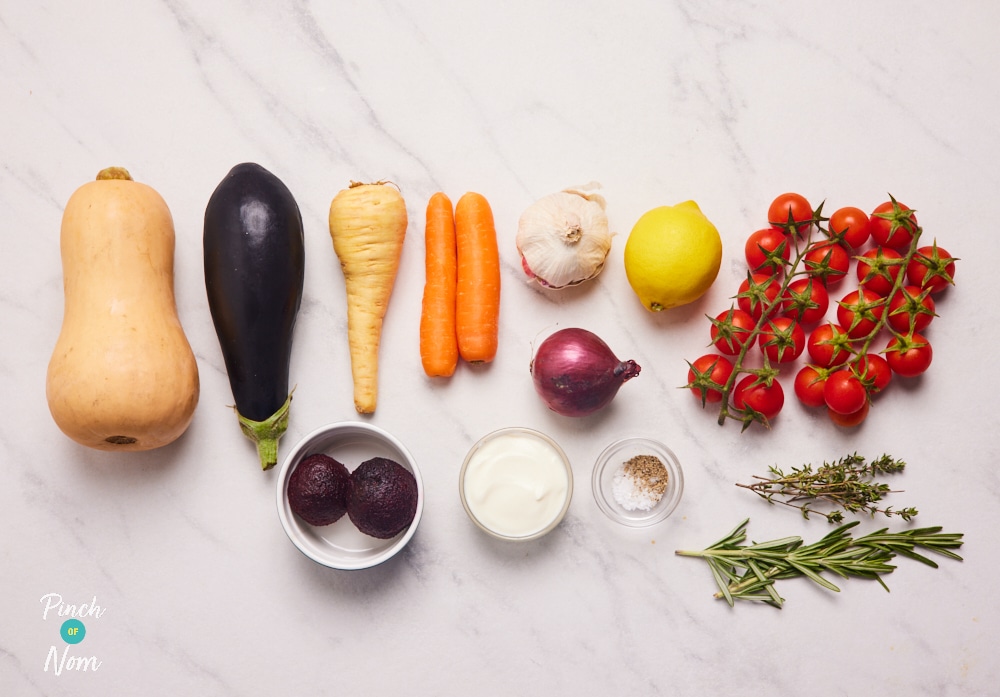 The ingredients for Pinch of Nom's Autumn Vegetable Traybake are laid out on a kitchen counter, ready to begin baking.