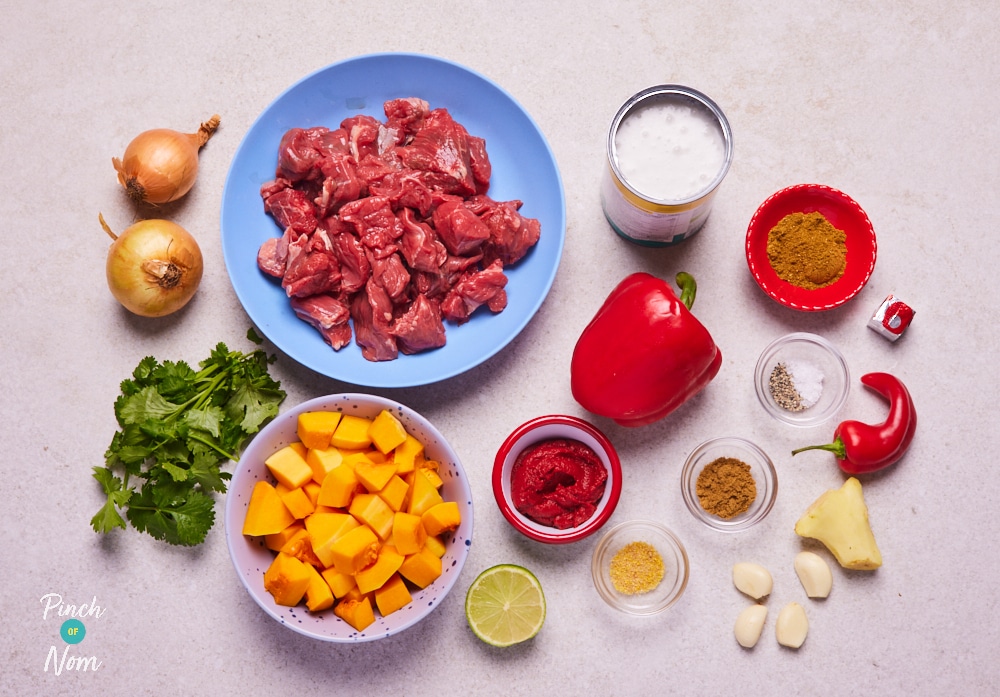 The ingredients for Pinch of Nom's Beef and Butternut Squash Curry are laid out on a kitchen surface, ready to begin cooking.