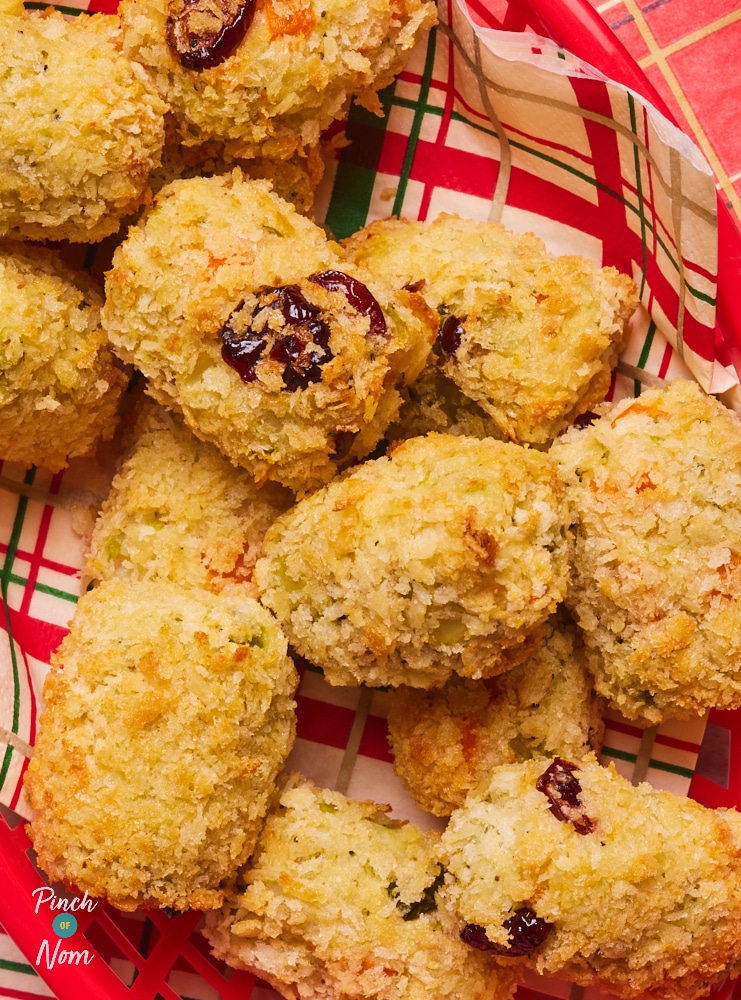 A close-up of a golden, crunchy-looking batch of Pinch of Nom's slimming-friendly Christmas Dinner Croquettes, in a bright red plastic basket.