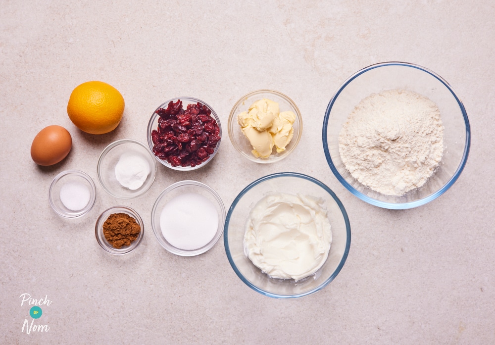 The ingredients for Pinch of Nom's Cranberry and Orange Muffins are laid out on a kitchen surface, ready to begin baking.