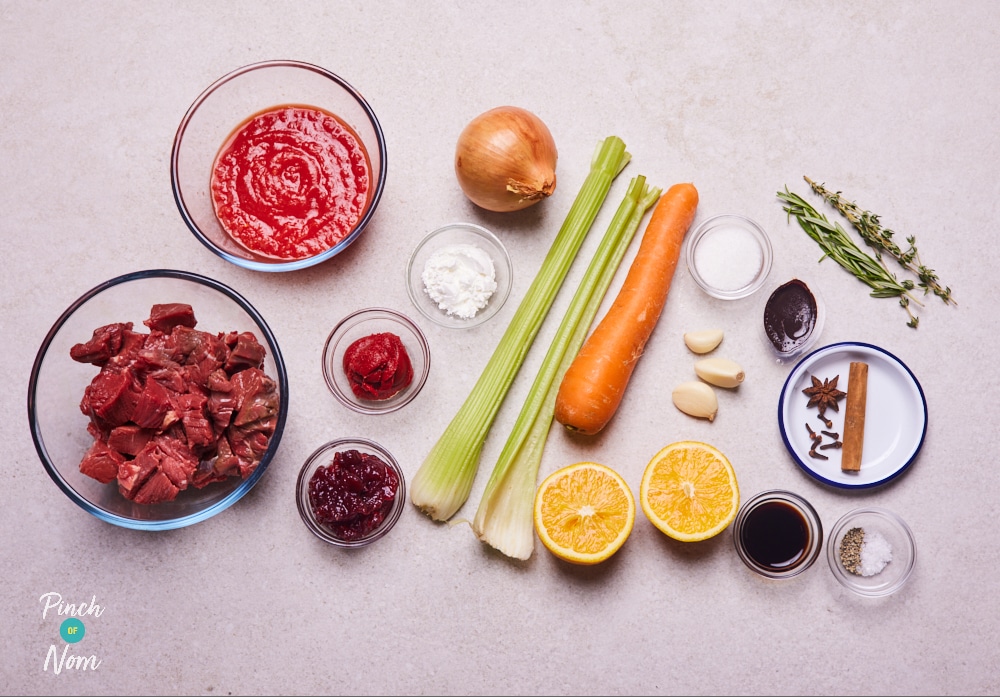 The ingredients for Pinch of Nom's Slow Cooker Mulled Wine Beef Stew are laid out on a kitchen counter, ready to begin cooking.