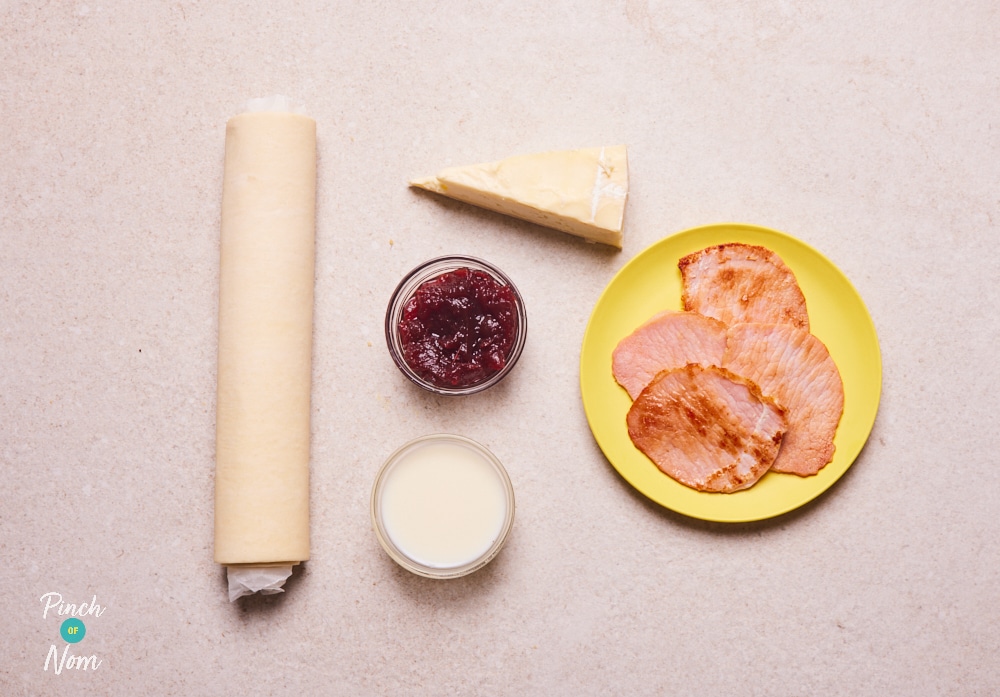 The ingredients for Pinch of Nom's Bacon, Brie and Cranberry Swirls are laid out on a kitchen surface, ready to begin cooking.