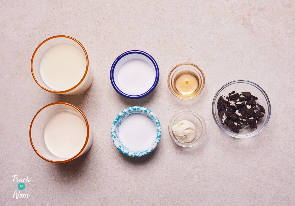 The ingredients for Pinch of Nom's low-calorie NInja Creami Cookies and Cream Ice Cream are laid out on a kitchen counter, ready to begin making the recipe.