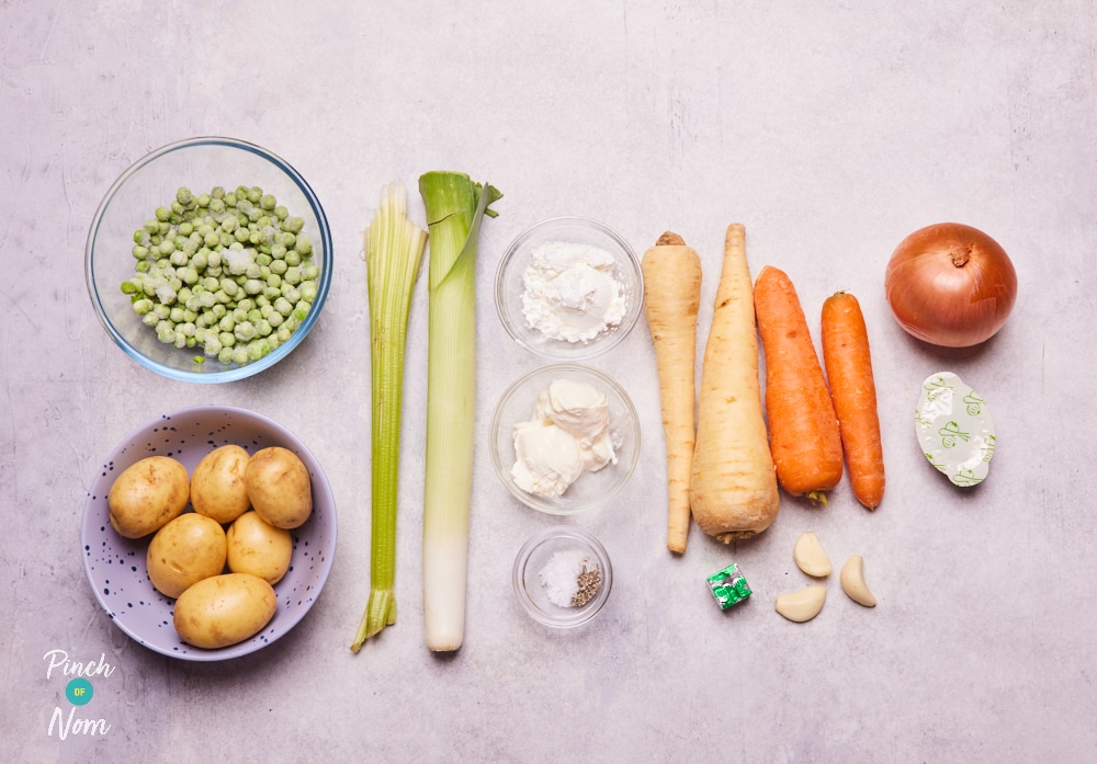 The ingredients for Pinch of Nom's Creamy Vegetable Soup are laid out on a kitchen counter, ready to begin cooking.