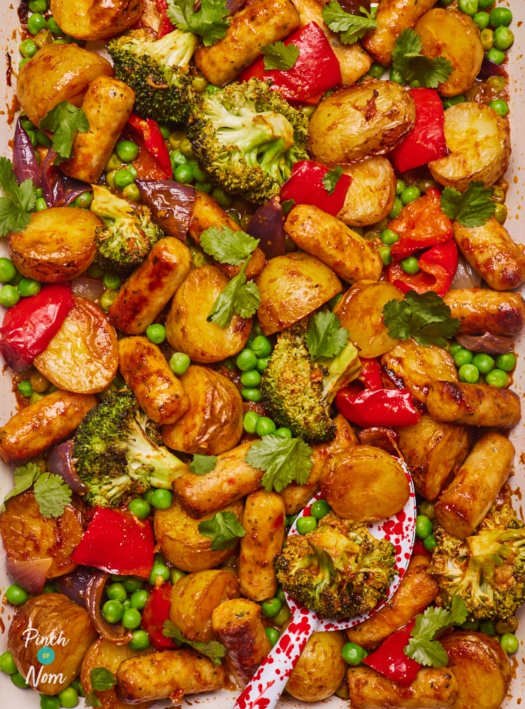 Pinch of Nom's slimming-friendly Curried Sausage Traybake is served fresh from the oven in a large ovenproof dish.