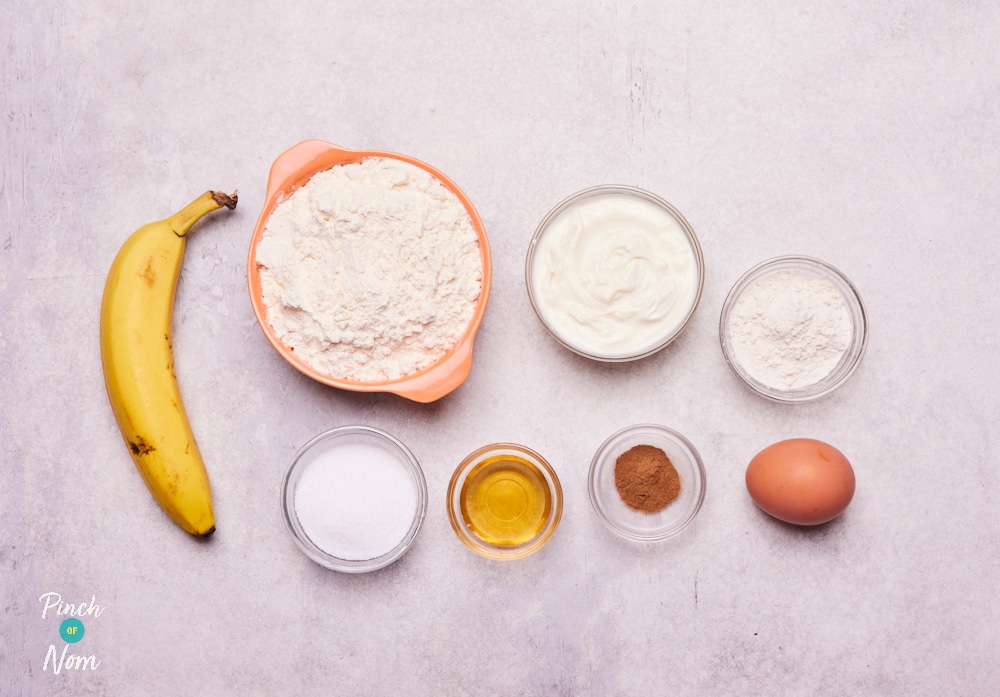 The ingredients for Pinch of Nom's Banana Bread Cinnamon Rolls are laid out on a kitchen counter, ready to begin baking.