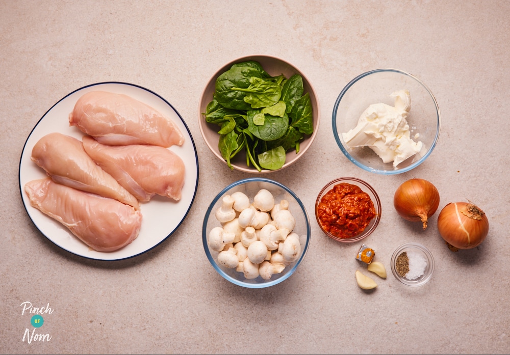 Ingredients for Creamy Pesto Chicken laid out on a countertop.