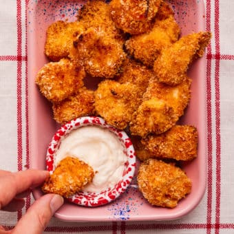 Pesto Chicken Nuggets served in a pink baking tray with a dip on the side.