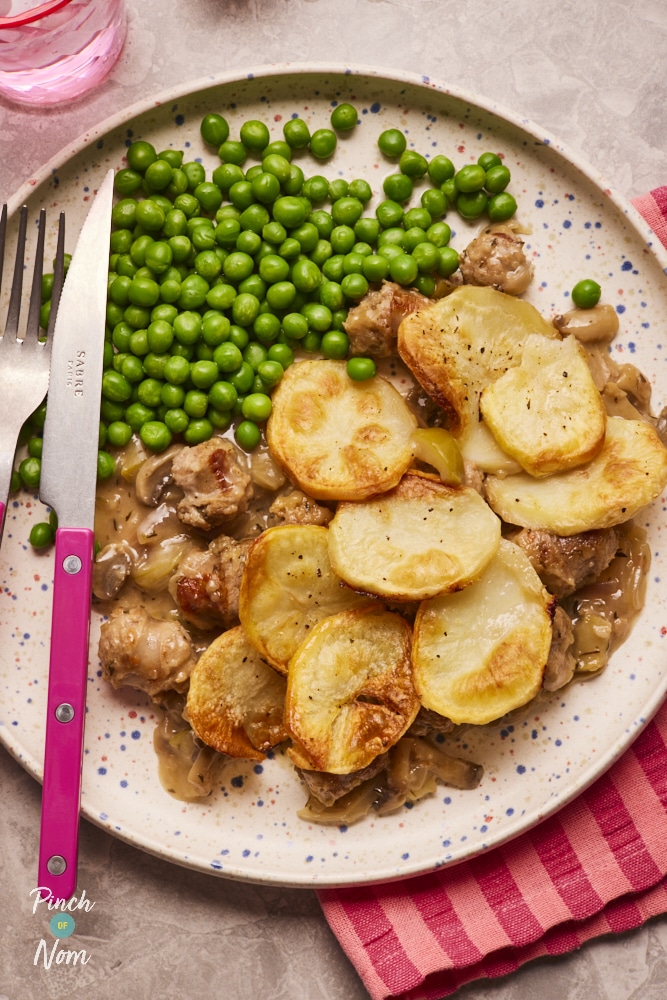 Sausage and Onion Hotpot, served on a plate with a side of garden peas.