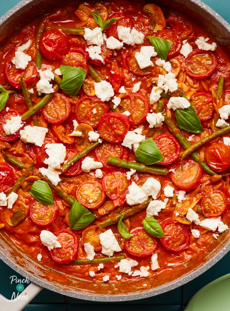 Pinch of Nom Roasted Red Pepper Feta Orzo, topped with feta and fresh basil leaves.